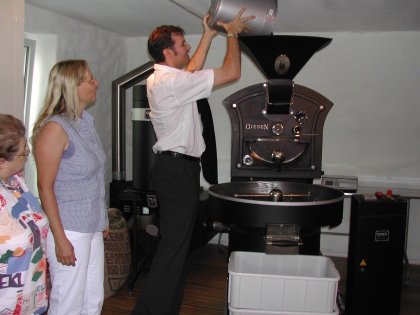 Der Chef, Kaffee-Diplomsommelier Peter Demmel, beschüttet die Röstmaschine